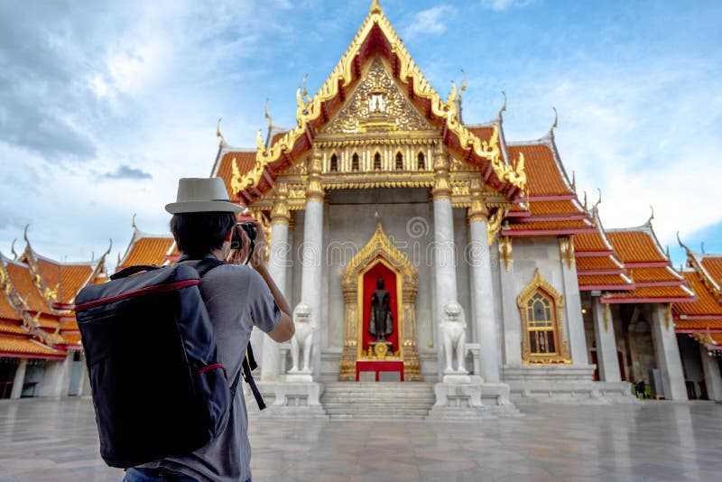 Eastern Asia summer holidays. Asian man tourist taking photos with cameras at Wat Benchamabopitr Dusitvanaram Bangkok Thailand. stock image Eastern Asia summer holidays. Asian man tourist taking photos with cameras at Wat Benchamabopitr Dusitvanaram Bangkok Thailand. stock image