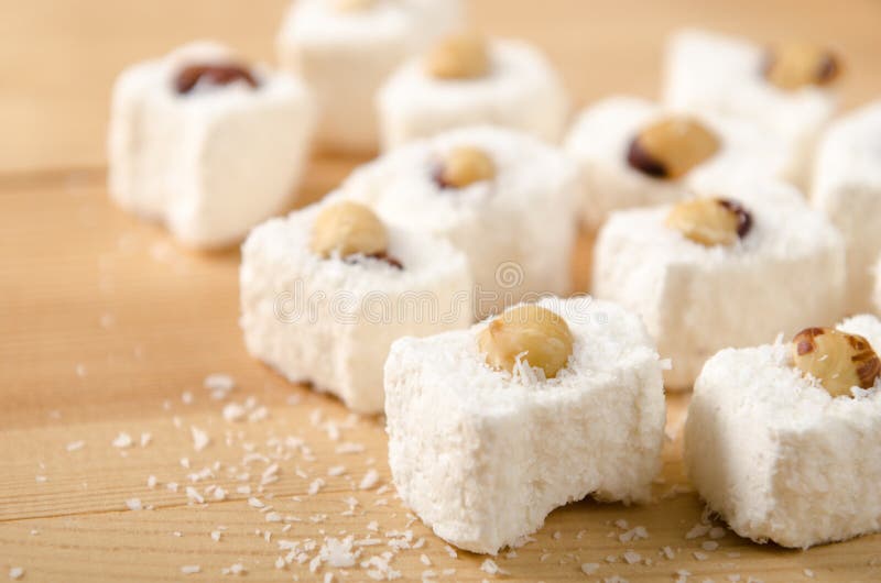 Eastern sweets, Turkish delight with coconut flakes, hazelnuts on wooden table stock photos Eastern sweets, Turkish delight with coconut flakes, hazelnuts on wooden table stock photos