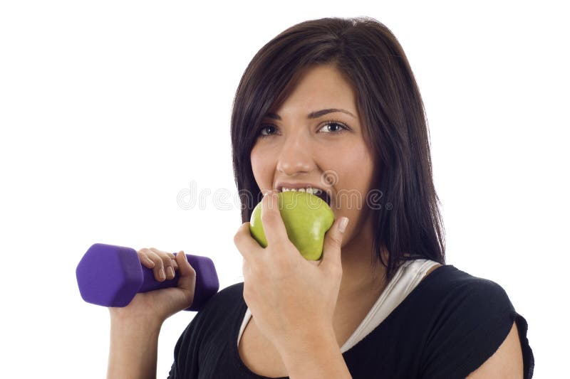 Attractive woman holding a dumbbell and eating a green apple - Eat right and exercise, Isolated over a white background. Attractive woman holding a dumbbell and eating a green apple - Eat right and exercise, Isolated over a white background