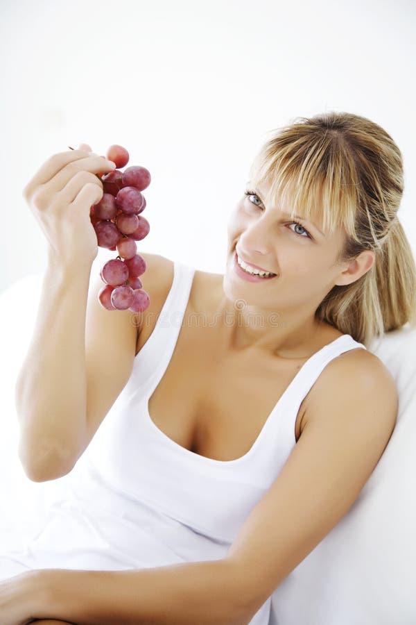 Young female eating a fresh bunch of red grapes. Young female eating a fresh bunch of red grapes