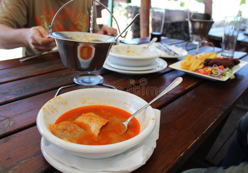 Eating outside - Hungarian fish soup halaszle and invisible eaters royalty free stock images Eating outside - Hungarian fish soup halaszle and invisible eaters royalty free stock images