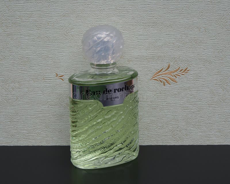 Eau de Rochas, parfum pour des dames, grande bouteille de parfum devant le wallcovering Elysee de satin photos stock Eau de Rochas, parfum pour des dames, grande bouteille de parfum devant le wallcovering Elysee de satin photos stock