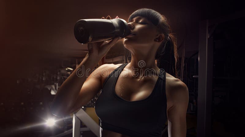 Eau potable de femme de forme physique de bouteille photographie stock libre de droits Eau potable de femme de forme physique de bouteille photographie stock libre de droits