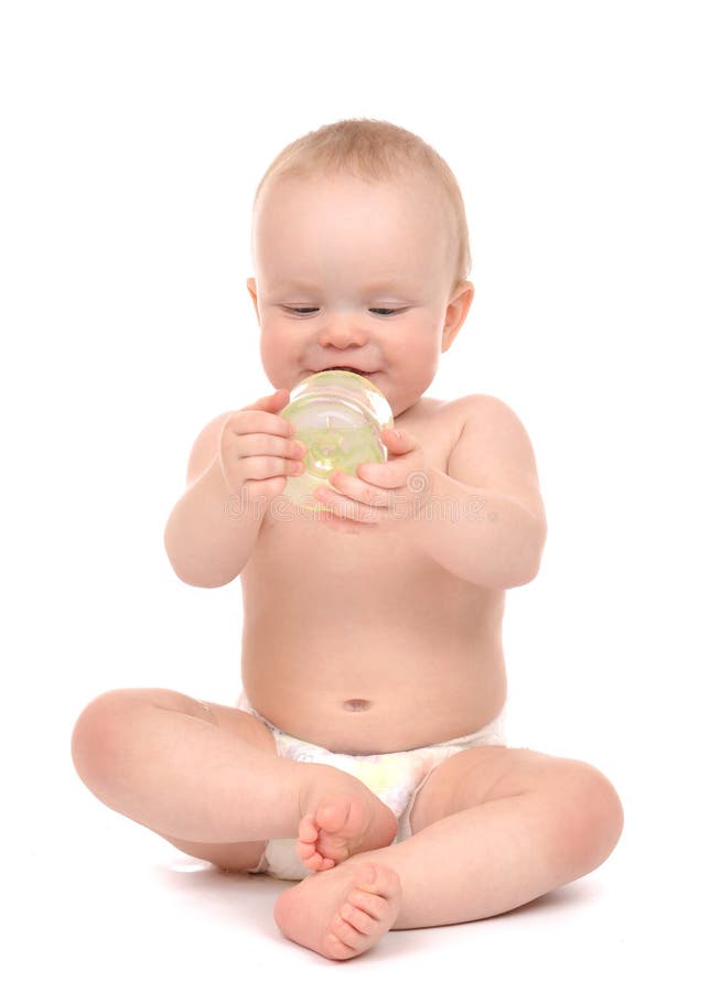 Infant child baby toddler sitting and drinking water from the feeding bottle isolated on a white background. Infant child baby toddler sitting and drinking water from the feeding bottle isolated on a white background