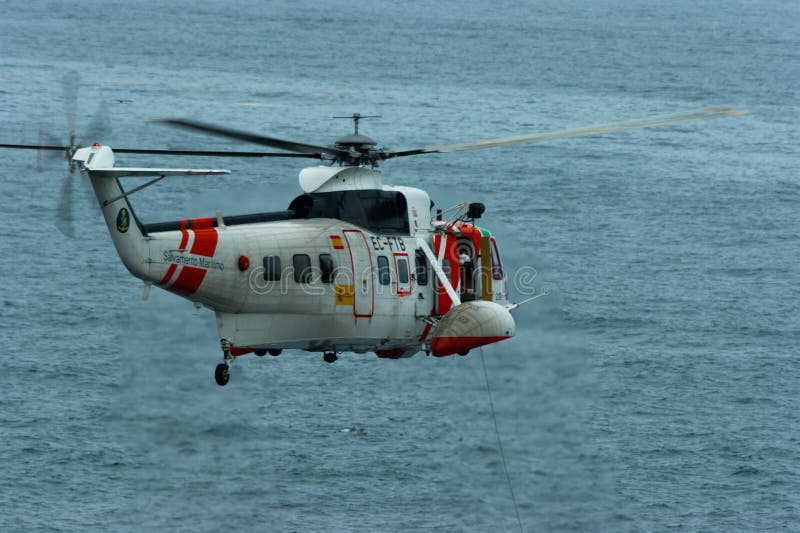 An ec225 Super Puma helicopter flies over the sea near the coast