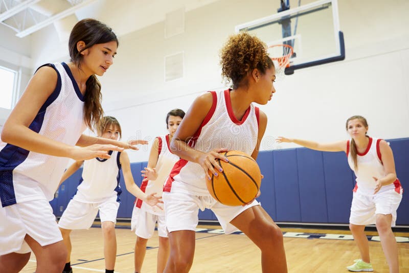 Echipă de baschet feminin din liceu care joacă jocuri de noroc stock photo