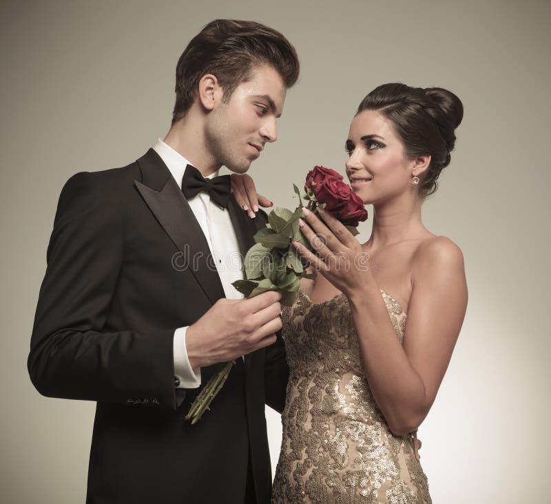 Echtgenoot die zijn mooie vrouw een bos van rode rozen aanbieden royalty-vrije stock foto's Echtgenoot die zijn mooie vrouw een bos van rode rozen aanbieden royalty-vrije stock foto's