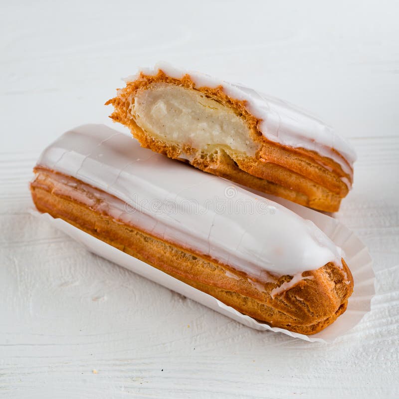 Eclairs franceses tradicionales llenos de crema de vainilla y azúcar en polvo. imágenes de archivo libres de regalías