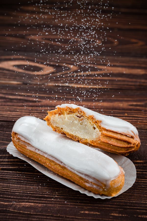 Eclairs franceses tradicionales llenos de crema de vainilla y azúcar en polvo. fotografía de archivo libre de regalías