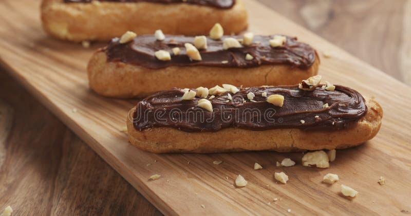 Eclairs with hazelnuts on wood board stock images Eclairs with hazelnuts on wood board stock images