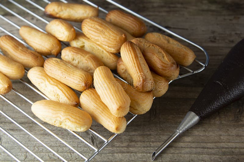 Eclairs ou profiterole que preparam-se na folha de cozimento Sobremesa francesa tradicional Cozinhando cookies caseiros, sobremes imagens de stock Eclairs ou profiterole que preparam-se na folha de cozimento Sobremesa francesa tradicional Cozinhando cookies caseiros, sobremes imagens de stock
