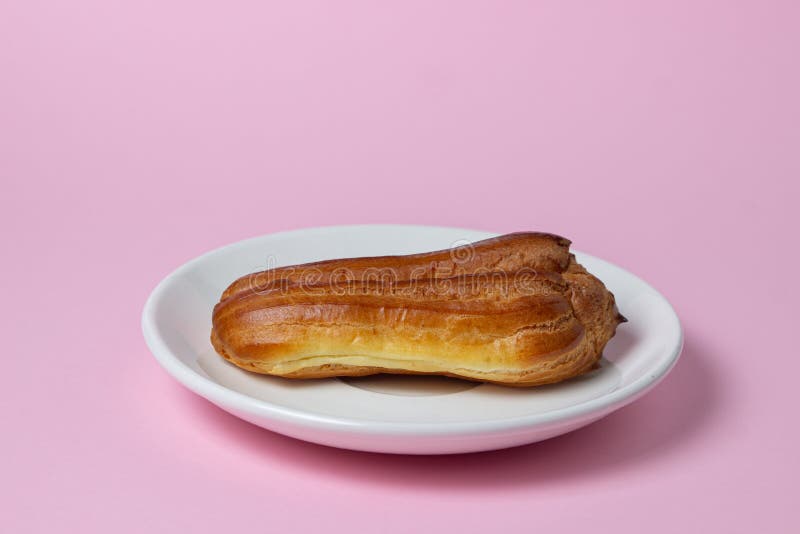 Eclairs sobre fondo rosa. un collar sobre una placa blanca. imágenes de archivo libres de regalías