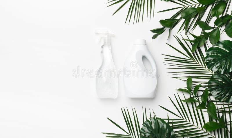 Eco cleaning detergent in white plastic bottles with green leaves