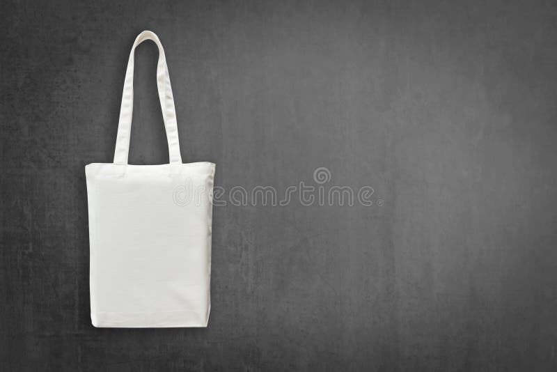 Eco cotton tote bag mock up white shopping fabric cloth sack with handle on blackboard background for mockup design backdrop