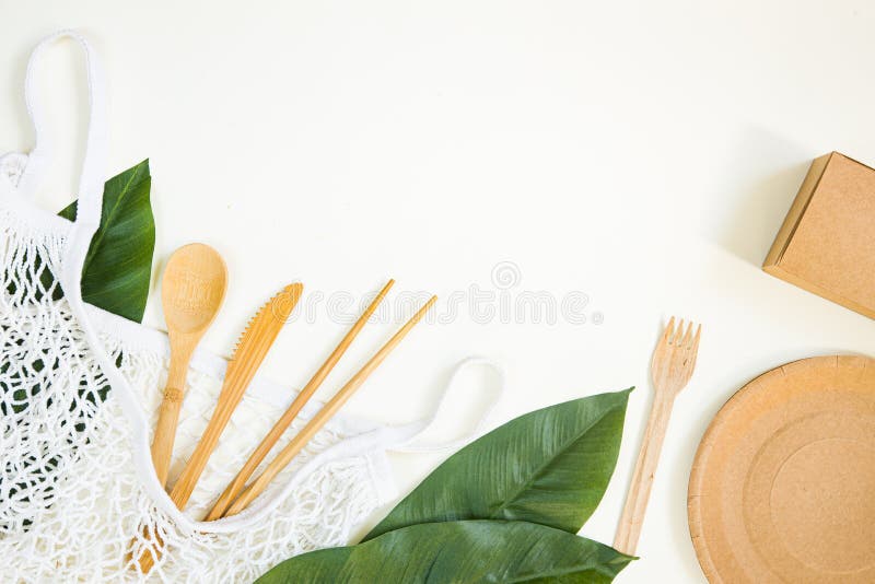 Eco freundliche Wegwerfteller haben Papier auf weißem Marmorhintergrund. drapierte Löffel Verbraucher Messerplatte mit Pappbechern lizenzfreies stockbild