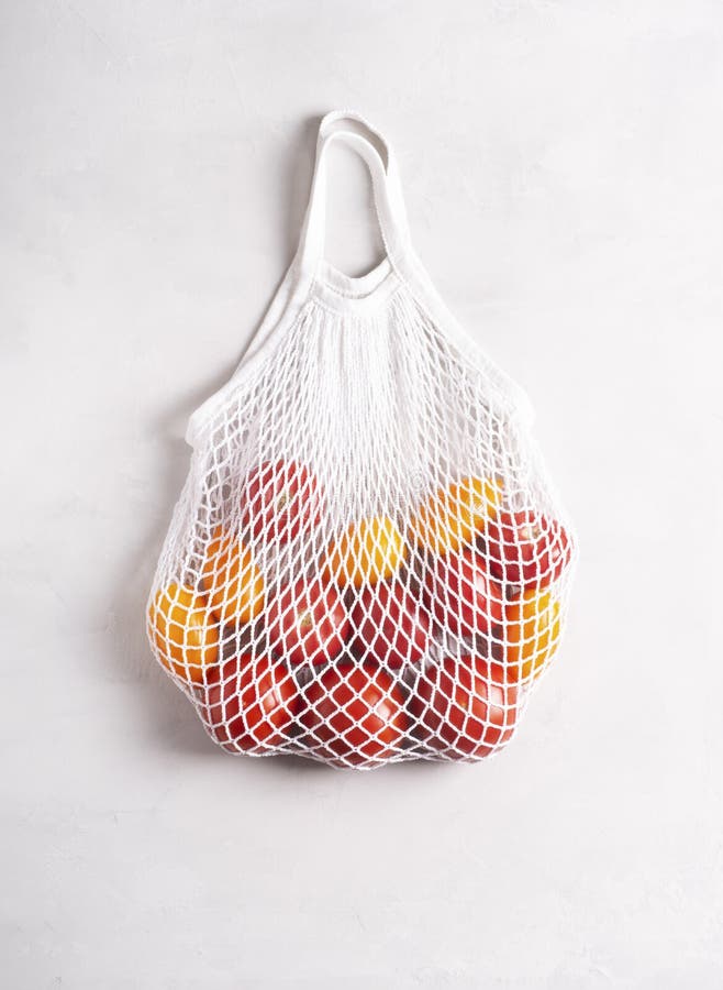Ecofriendly Mesh Bag with Tomatoes on a Gray Surface, Flat Lay, Top