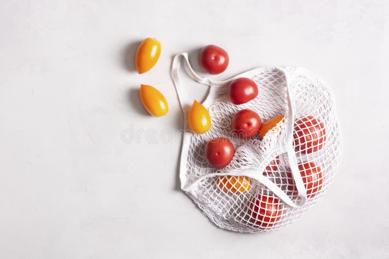 Ecofriendly Mesh Bag with Tomatoes on a Gray Surface, Flat Lay, Top