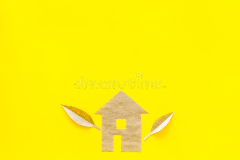 Eco friendly technologies for home concept. House silhouette made of craft paper on yellow background top view copy stock photo Eco friendly technologies for home concept. House silhouette made of craft paper on yellow background top view copy stock photo