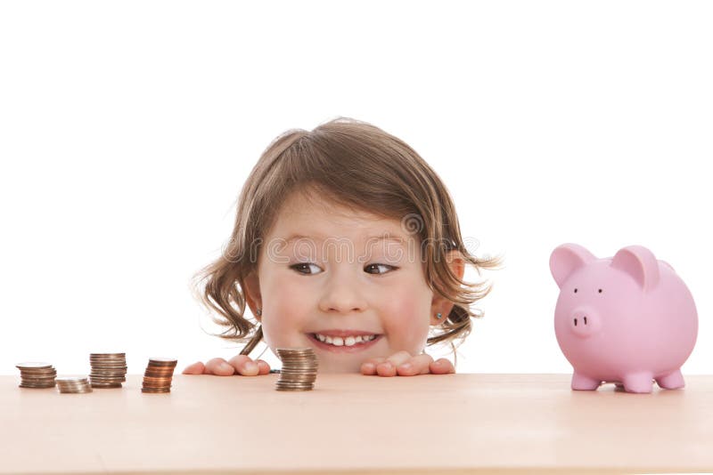 Adorable preschooler peeking over a desk at piles of sorted money and a pink piggy bank. Isolated on white with room for your text. Adorable preschooler peeking over a desk at piles of sorted money and a pink piggy bank. Isolated on white with room for your text.