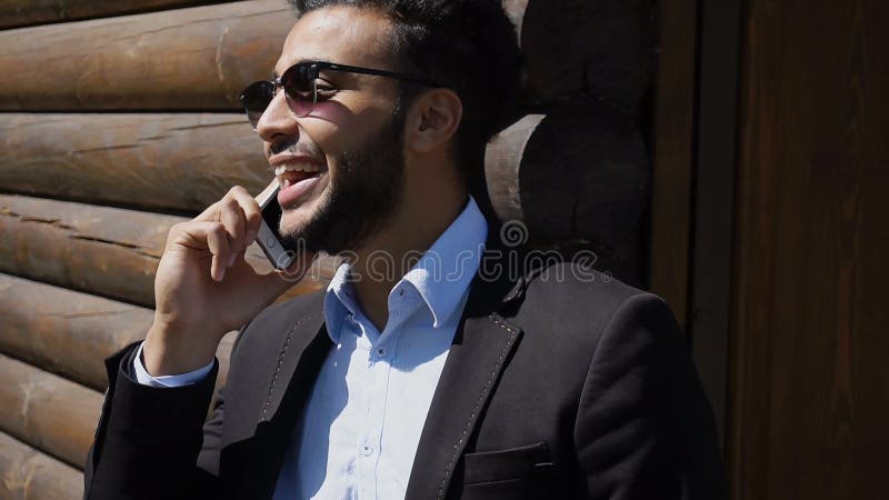 Economista que fala com o chefe no telefone, sorrindo com ondulações no fá imagem de stock Economista que fala com o chefe no telefone, sorrindo com ondulações no fá imagem de stock