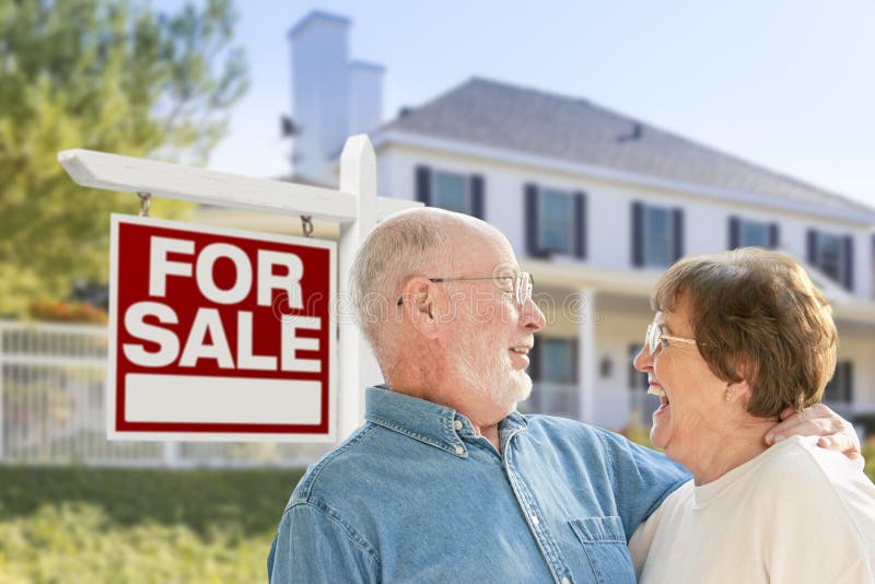 Happy Senior Couple Front of For Sale Real Estate Sign and House. Happy Senior Couple Front of For Sale Real Estate Sign and House.