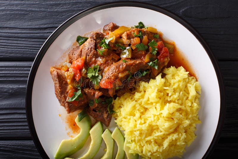 Ecuadorian seco de chivo stewed goat meat with a side dish of ye