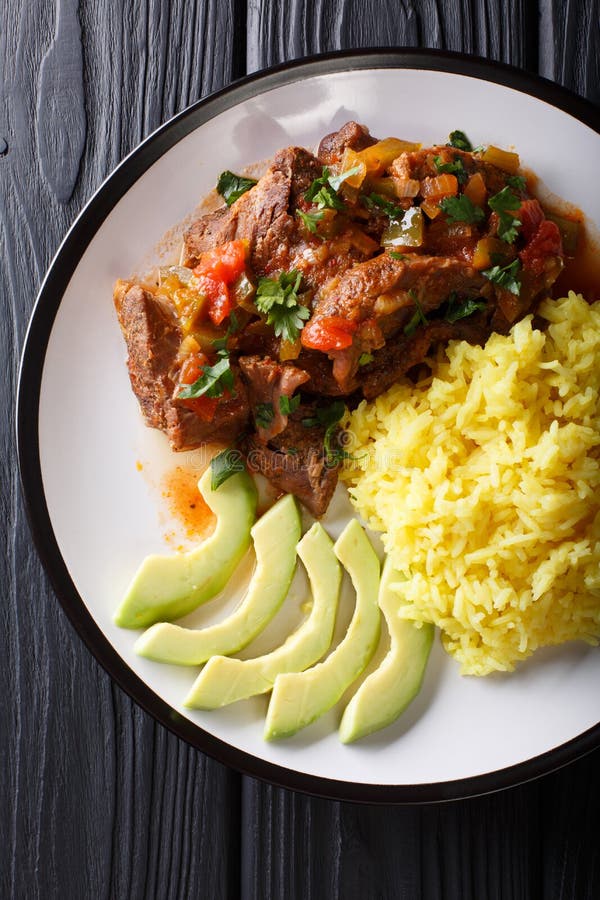 Ecuadorian seco de chivo stewed goat meat with a side dish of ye