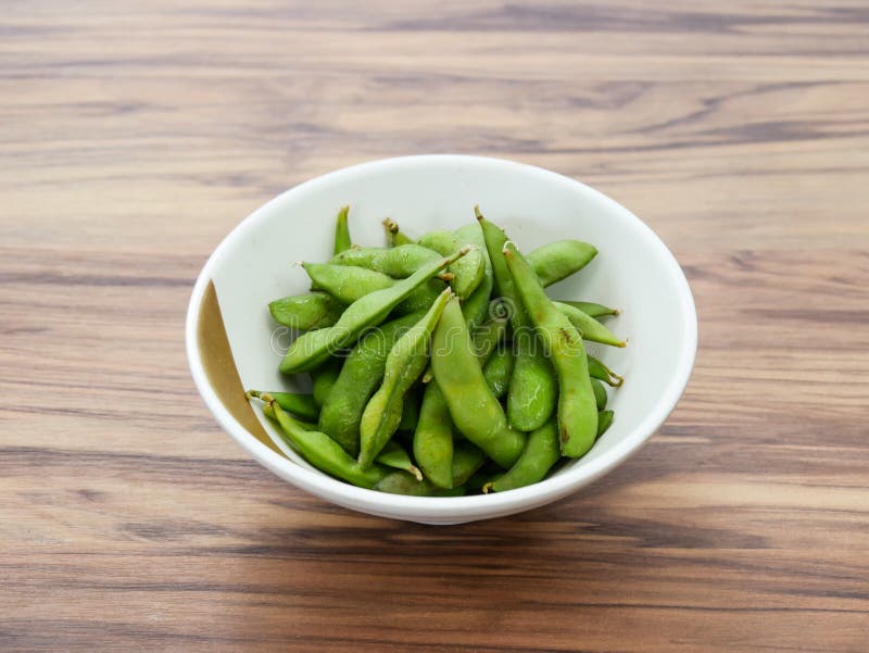 Edamame-sojabönor i poder som serveras i tarm som är isolerade på bordssidan av japansk mat royaltyfria foton