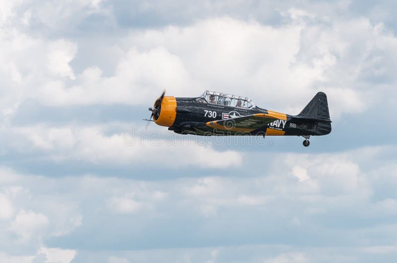 EDEN PRAIRIE, MN - JULY 16, 2016: AT-6 Texan flies by with gear up at air show. The AT-6 Texan was primarily used as trainer aircraft during and after World War II. EDEN PRAIRIE, MN - JULY 16, 2016: AT-6 Texan flies by with gear up at air show. The AT-6 Texan was primarily used as trainer aircraft during and after World War II.