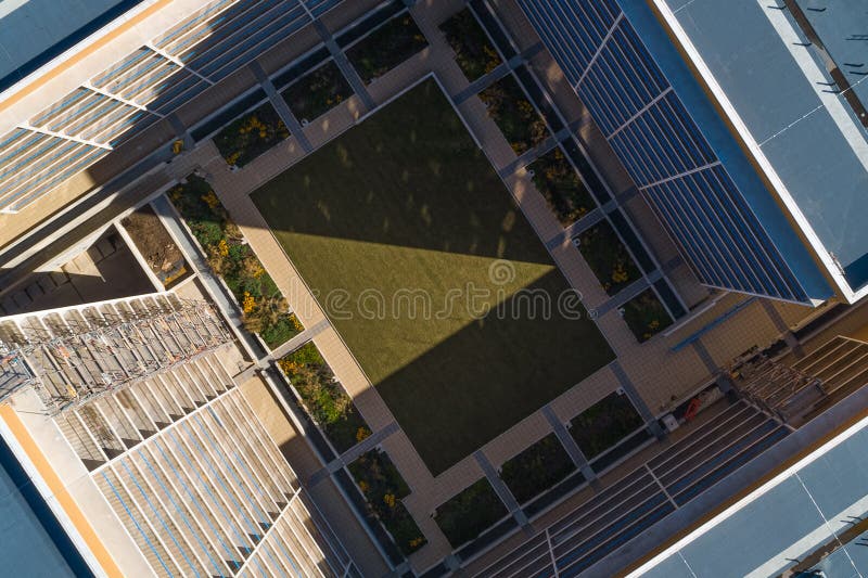 Edificio astratto ad alto sviluppo con quadrato verde dal drone aereo fotografia stock libera da diritti