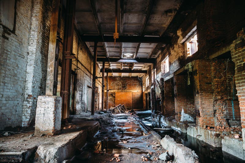 Edificio industrial arruinado abandonado de la fábrica, opinión del pasillo con perspectiva, ruinas y concepto de la demolición