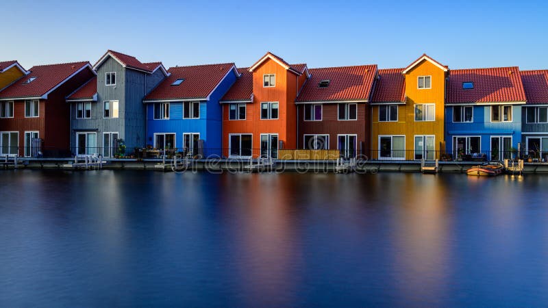 Edificios coloridos fant?sticos en el agua en la hora azul, Groninga, Pa?ses Bajos imagen de archivo Edificios coloridos fant?sticos en el agua en la hora azul, Groninga, Pa?ses Bajos imagen de archivo