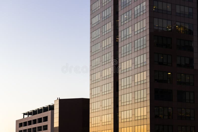 Edificios modernos de oficinas y edificios residenciales altos en vidrio, acero y hormigón que reflejan los colores dorados de la imágenes de archivo libres de regalías Edificios modernos de oficinas y edificios residenciales altos en vidrio, acero y hormigón que reflejan los colores dorados de la imágenes de archivo libres de regalías