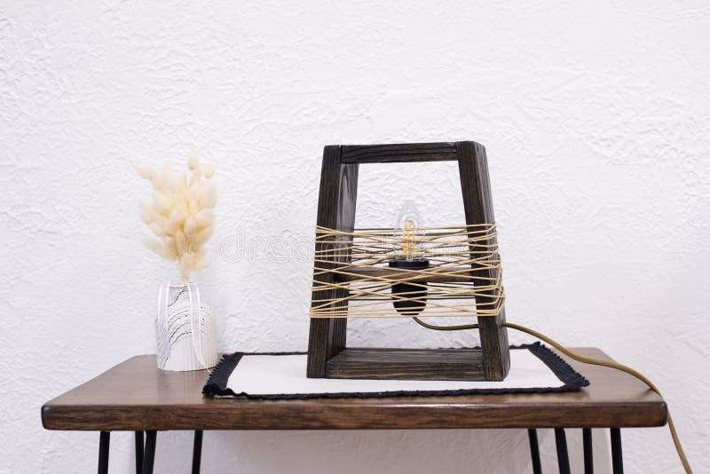 Edison table lamp on the table. A stylish wooden lamp in a loft style. Night lamp light bulb. stock photo