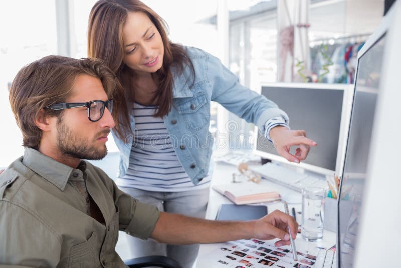 Editors choosing photos on computer screen at their desk. Computer editing stock images, royalty-free photos and pictures
