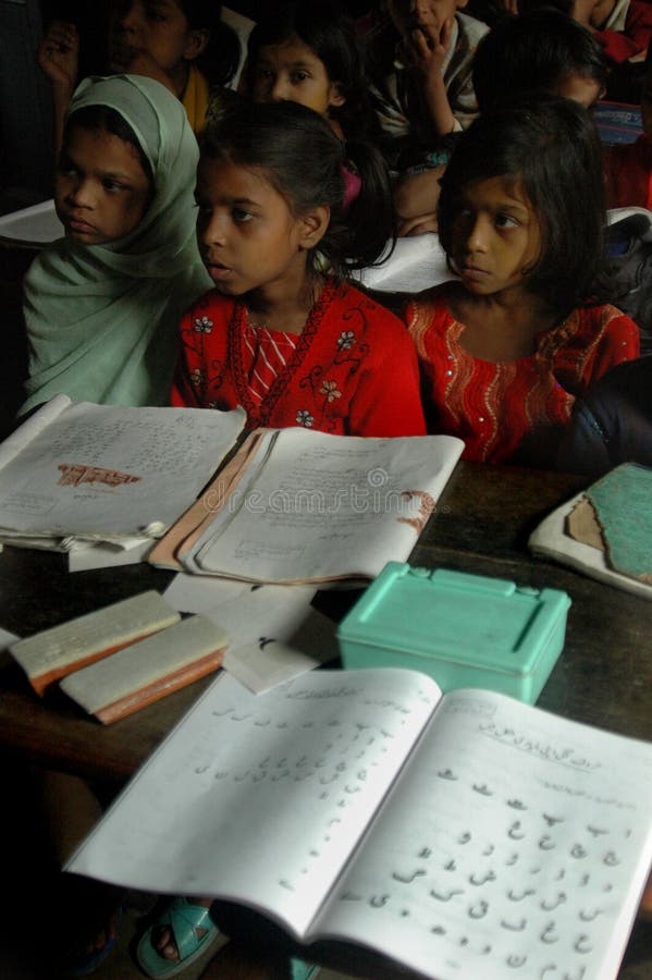 A Muslim teacher is teaching with personal care of Muslim children in a classroom of a slum area in India. A Muslim teacher is teaching with personal care of Muslim children in a classroom of a slum area in India.