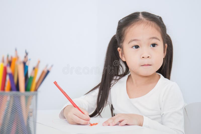 Educación y concepto de la escuela, pequeño dibujo asiático de la muchacha del estudiante con los lápices en la escuela fotografía de archivo libre de regalías Educación y concepto de la escuela, pequeño dibujo asiático de la muchacha del estudiante con los lápices en la escuela fotografía de archivo libre de regalías