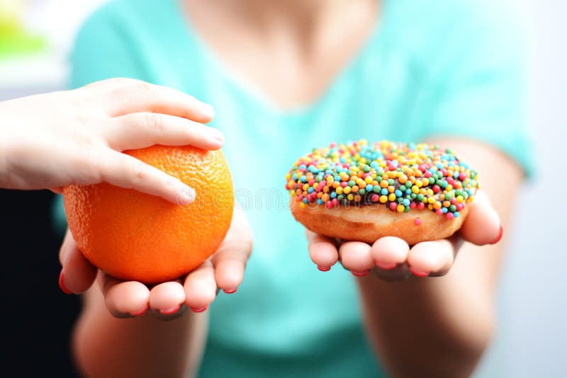 Educate children to choose healthy food concept with little girl choice to eat fruit, not a donut. Educate children to choose healthy food concept with little stock photo Educate children to choose healthy food concept with little girl choice to eat fruit, not a donut. Educate children to choose healthy food concept with little stock photo
