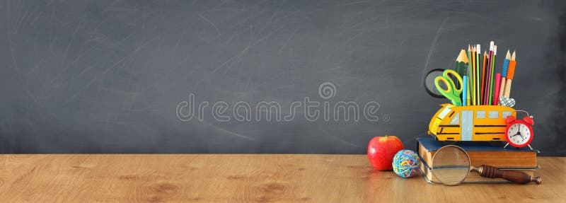 Education and back to school concept. pencils stand as bus over wooden desk infront of classroom blackboard stock images