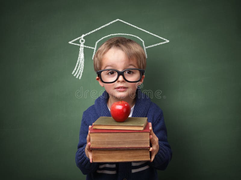 Bambino che tiene pila di libri con malta bordo di gesso disegno sulla lavagna concetto per la formazione universitaria e le aspirazioni future.