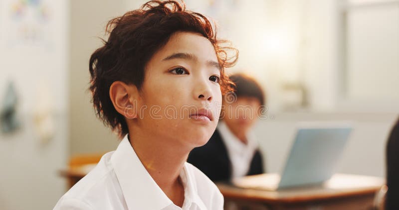Education, child or thinking in class for learning, daydreaming and distracted in lesson. Japanese boy, face or student royalty free stock image