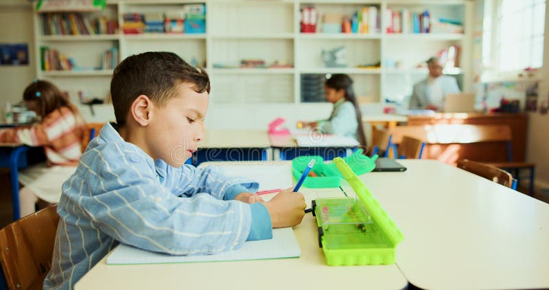 Education, child and writing in classroom for learning, lesson and creativity with stationery. Kid, notebook and drawing royalty free stock image