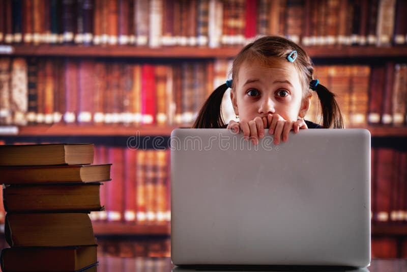 Education concept. Portrait of young beautiful child girl working  with laptop and reading books in library. Horizontal image