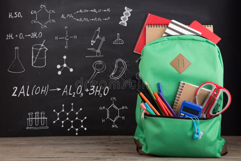 Education concept - school backpack with books and other supplies, blackboard background stock images