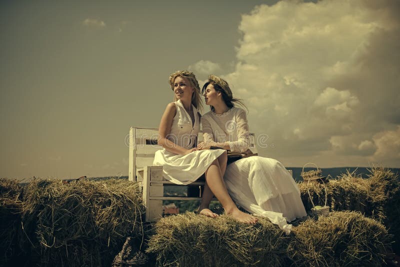 Education and knowledge concept. Two girls reading books on bench on hay