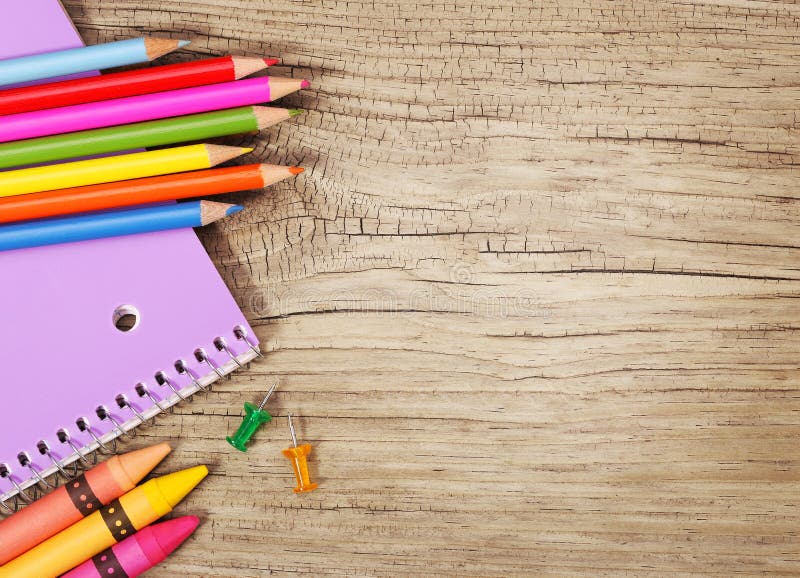 Education supplies on old wooden background. Colorful pencils