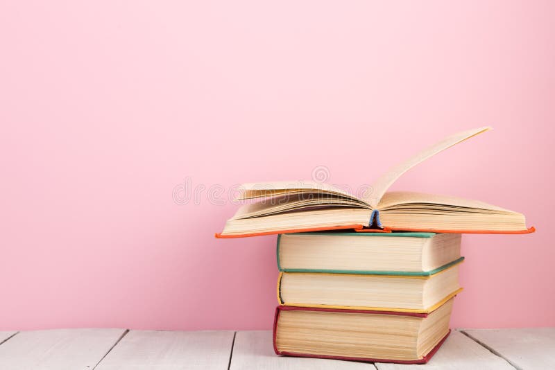 education and wisdom concept - open book on wooden table, color background