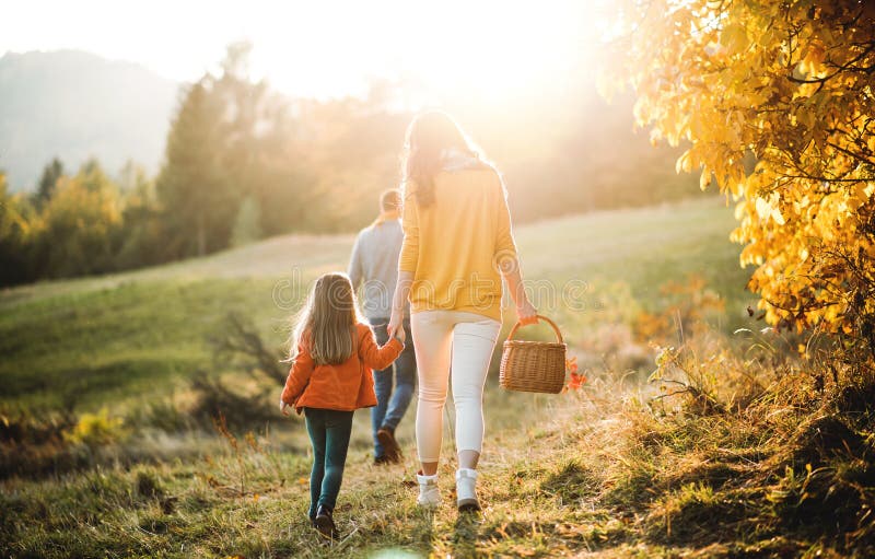 Een achteraanzicht van het gezin met een klein kind op een wandeling in de herfst stock foto's Een achteraanzicht van het gezin met een klein kind op een wandeling in de herfst stock foto's
