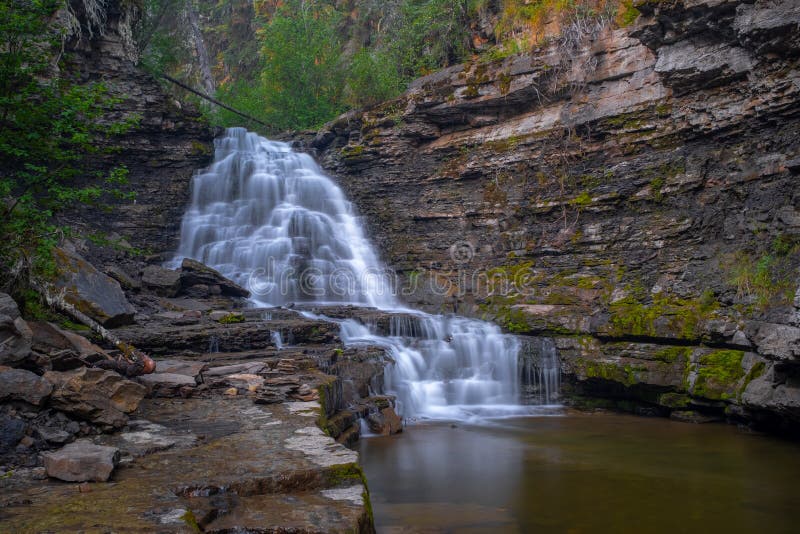 A distance shot of  Quality Waterfall near Tumbler Ridge, British Columbia, Canada, long exposure to smooth out the water and create a milky effect. A distance shot of  Quality Waterfall near Tumbler Ridge, British Columbia, Canada, long exposure to smooth out the water and create a milky effect