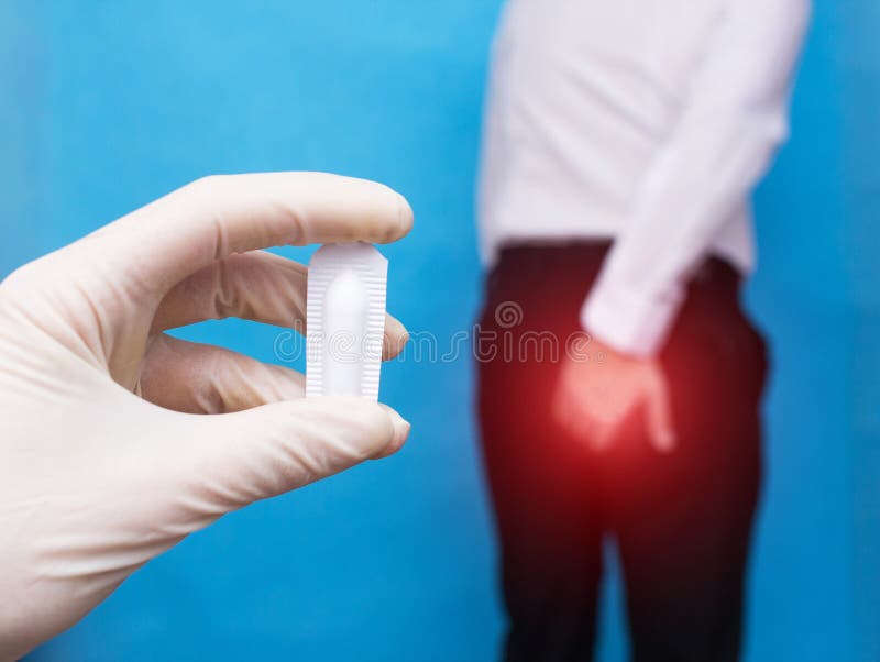 Een arts houdt een het helen zetpil van problemen met het rectum en de hemorroïden, de man houden op de anus van het probleem stock fotografie Een arts houdt een het helen zetpil van problemen met het rectum en de hemorroïden, de man houden op de anus van het probleem stock fotografie